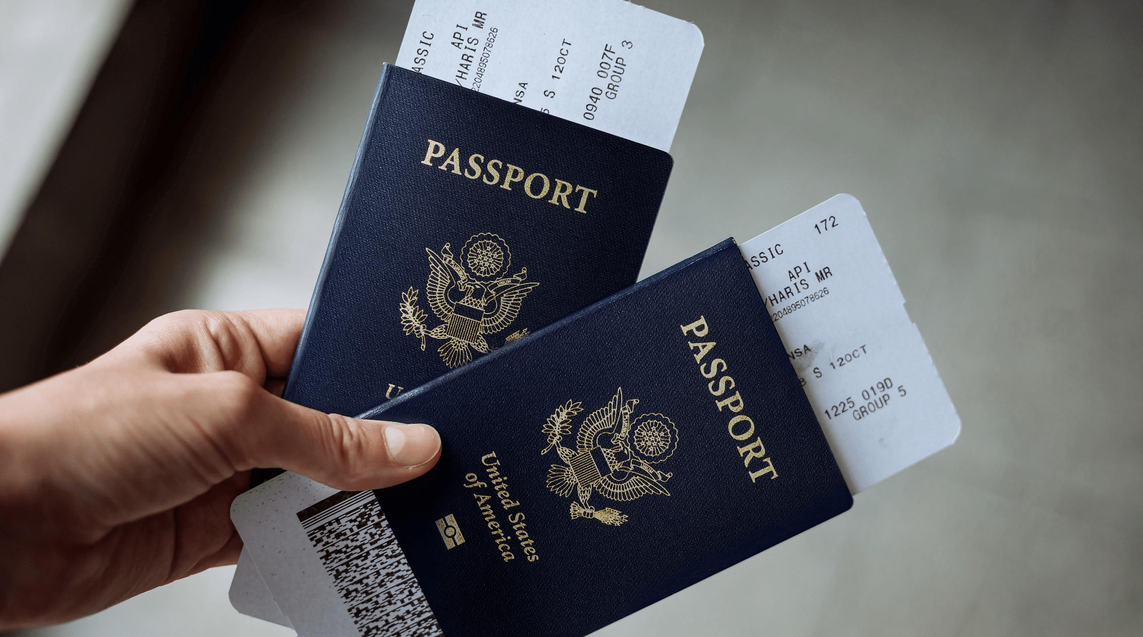 hand holding two passports and boarding passes