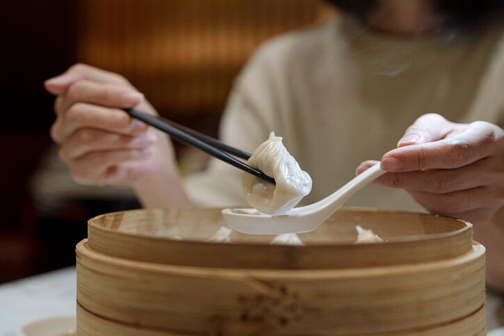 Woman eating dumpling dish for Chinese New Year 