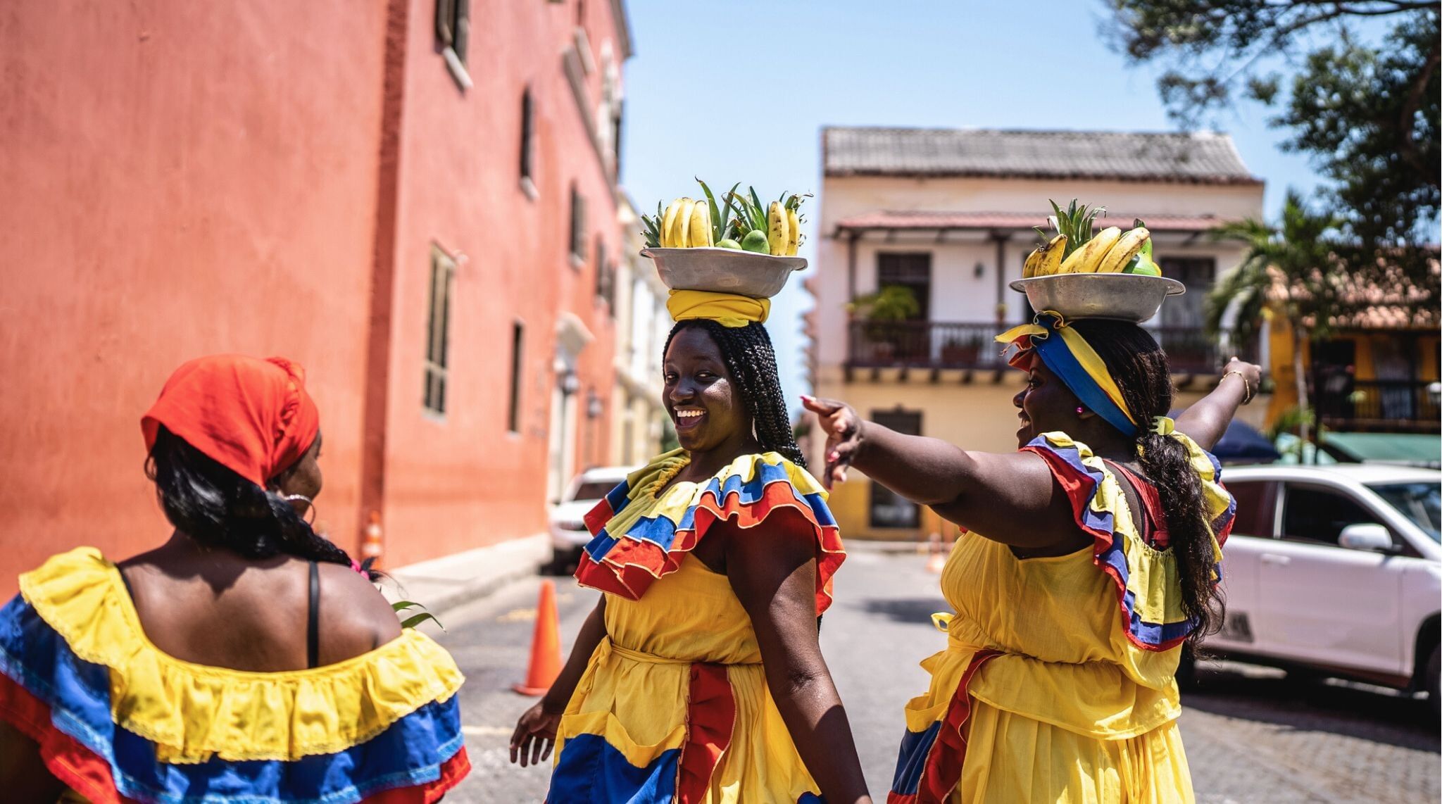 Palenqueras se divertem enquanto vendem frutas na rua em Cartagena.