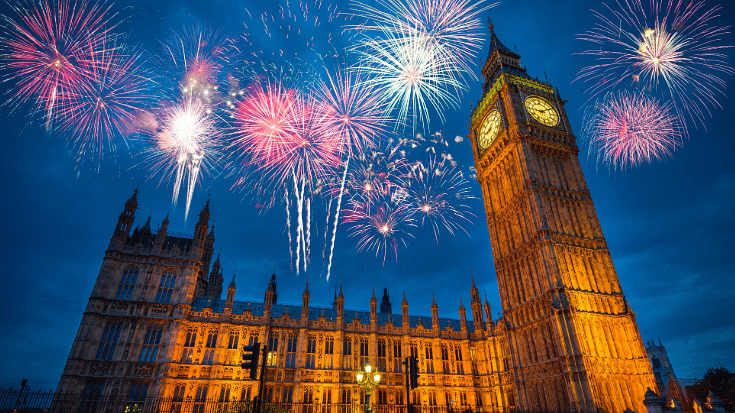 An image of red, pink and white fireworks exploding against a blue sky with London's Westminster buildings in the background, to illustrate a blog post entitled 'How to Spend New Year's Eve in London'.