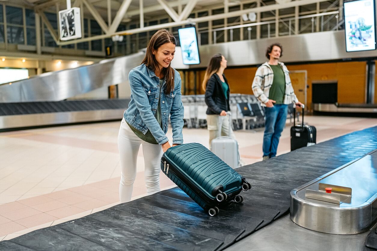 Woman with luggage at airport’s baggage carousel