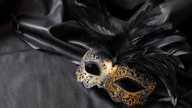 An image of a masquerade mask in black with black feathers coming from the top to illustrate a blog post entitled 'How to Spend New Year's Eve in London'.