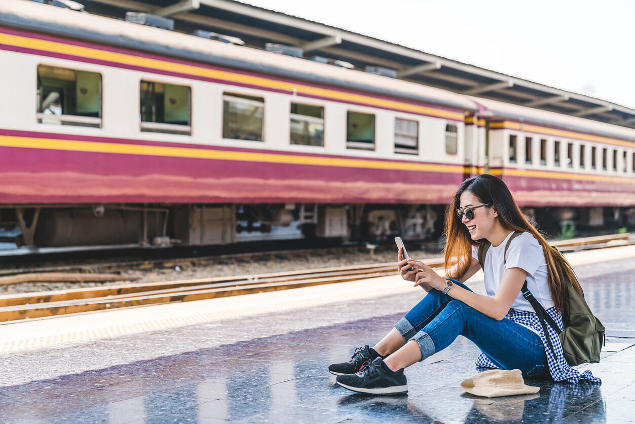 Frau am Bahnhof mit Internet in Thailand