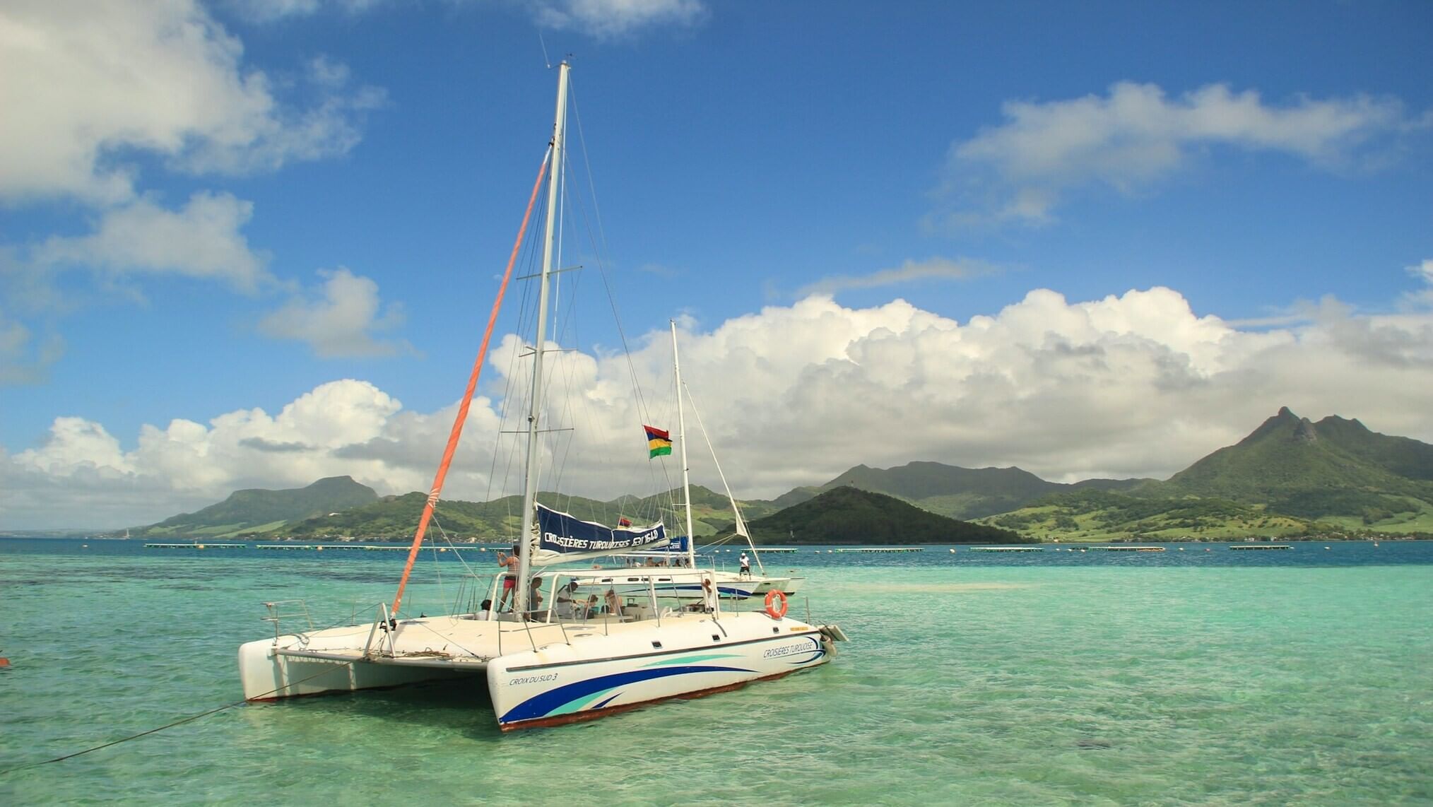 A boat on a body of water with mountains at a distance in Mauritius