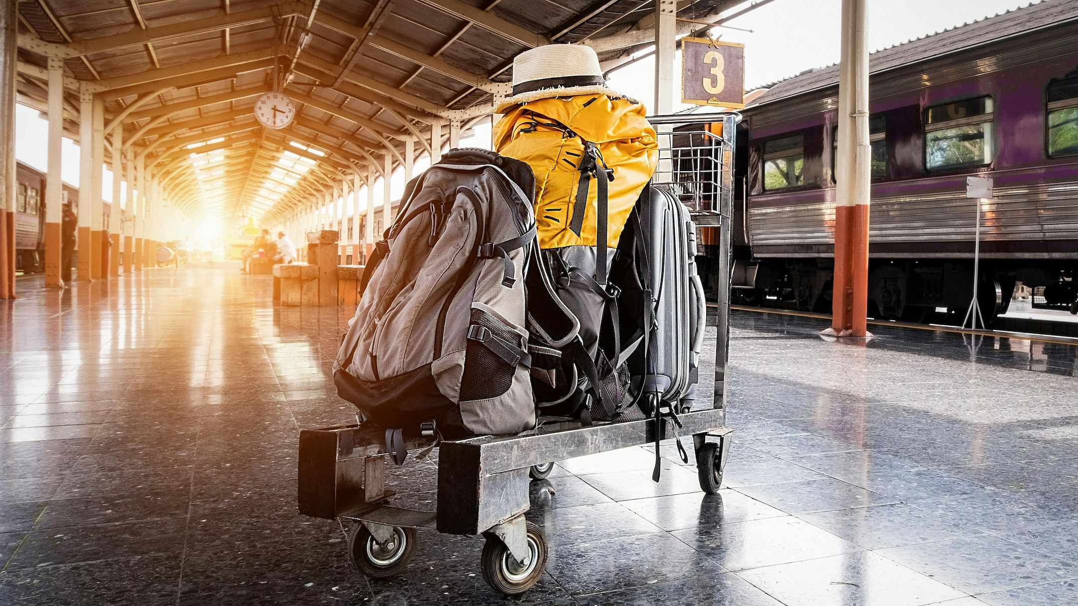 Luggage on a train platform at sunset