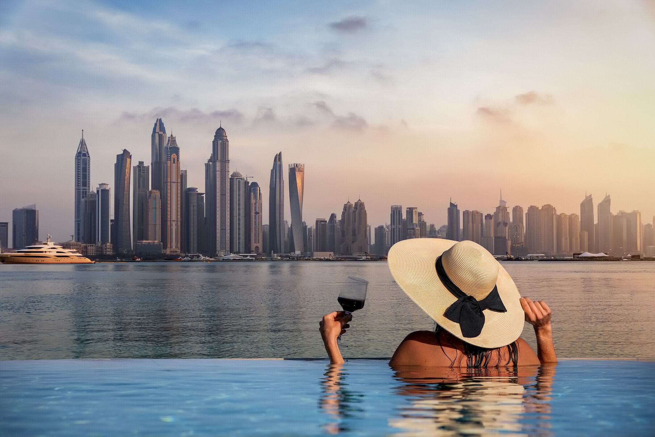 Frau im Pool vor der Skyline von Dubai