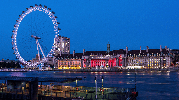 A photograph of the London Eye ferris wheel over the River Thames at dusk to illustrate a blog post entitled 'How to Spend New Year's Eve in London'.