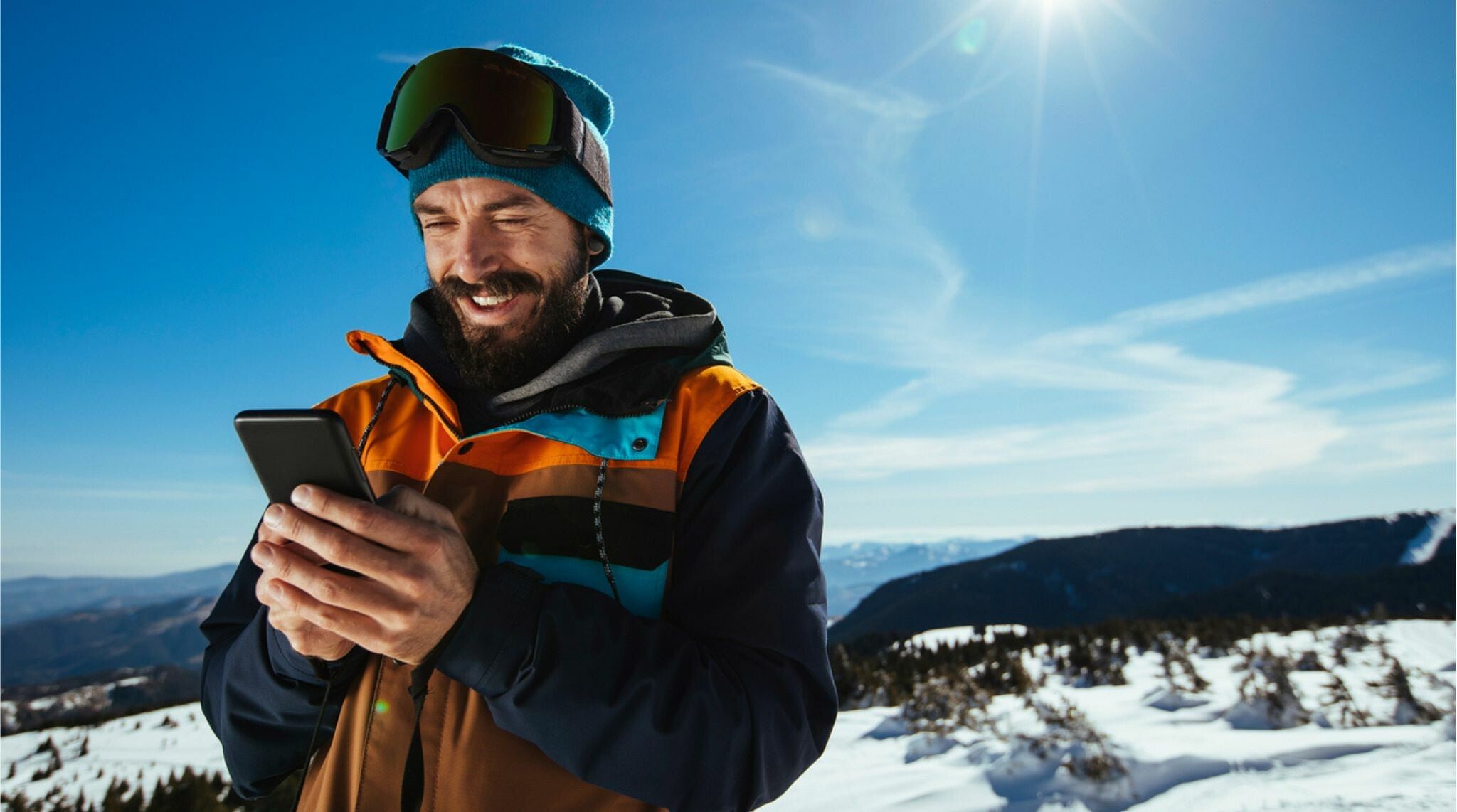 homem usando celular na neve
