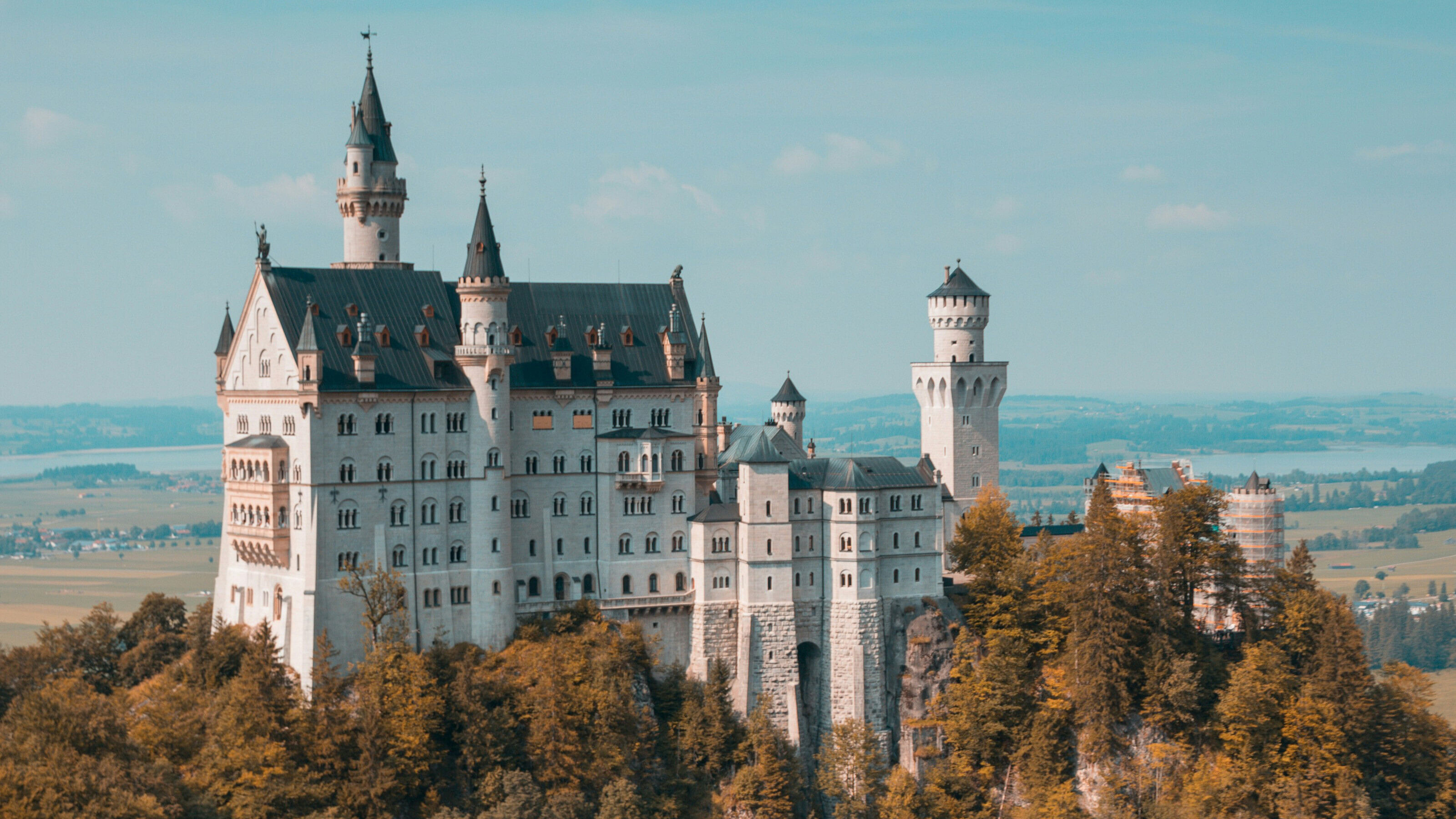 A scenic view of Neuschwanstein Castle surrounded by trees