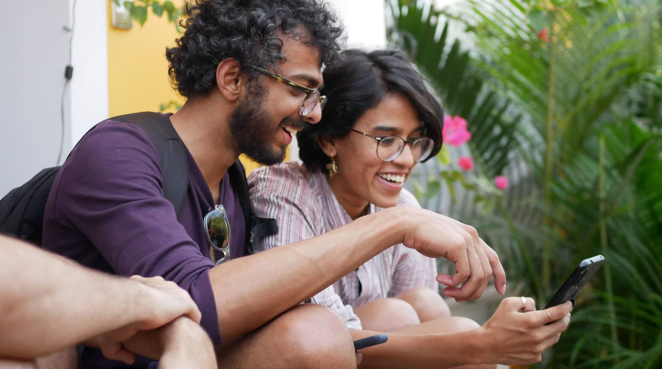 uomo e donna che sorridono e guardano un telefono