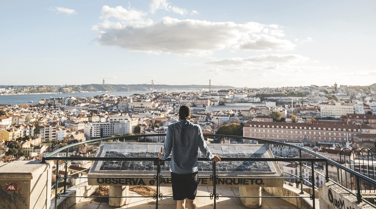 Traveler looking at the view from Miradouro da Senhora do Monte in Lisbon