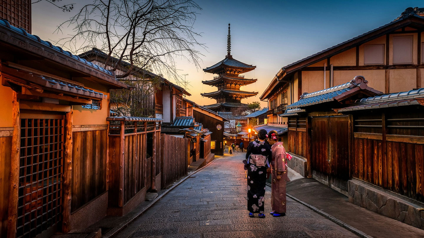 Two women on a walk through a cozy Kyoto street