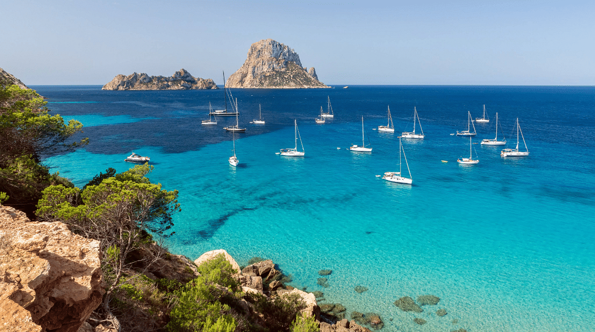 Bay with boats and an island in Ibiza, Spain