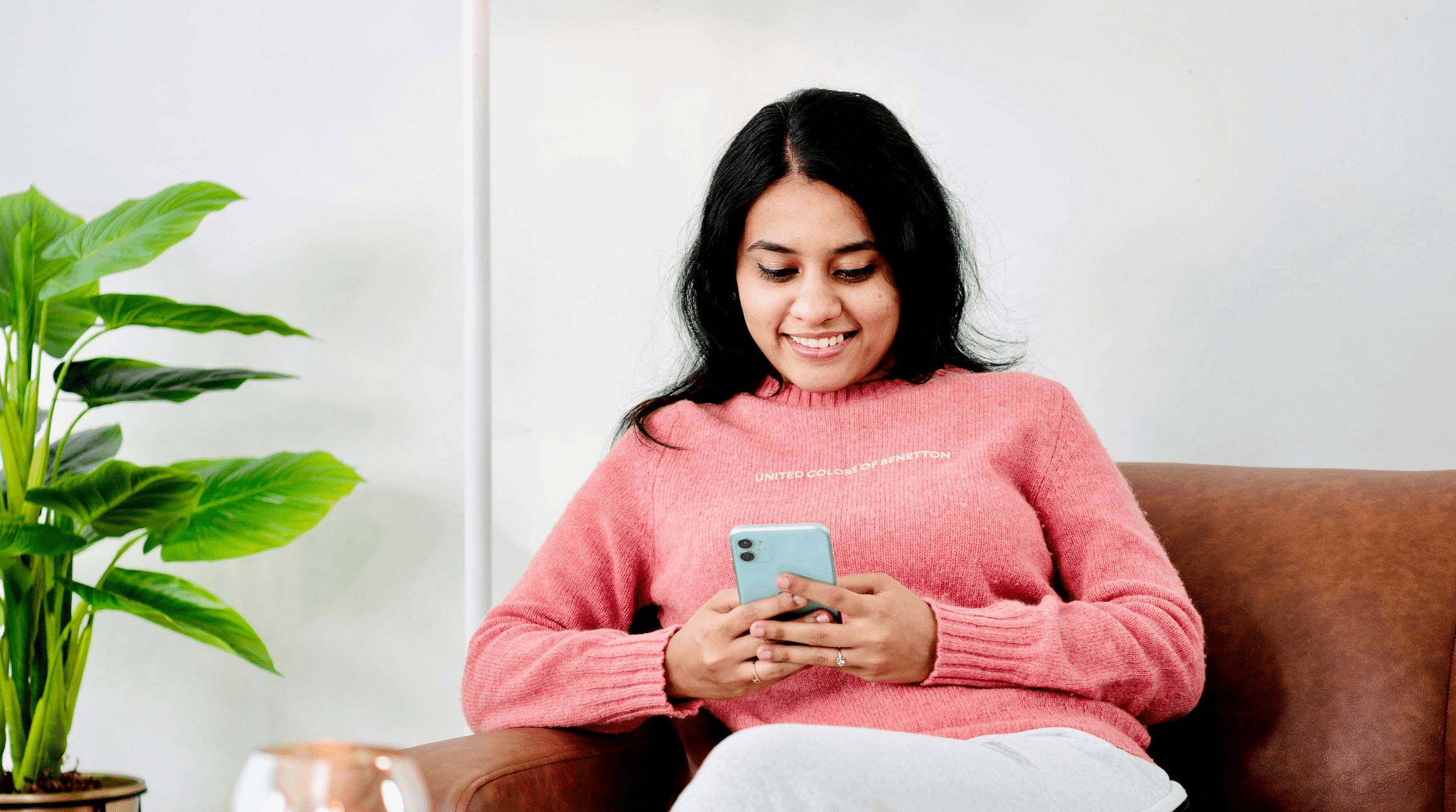 woman sitting on couch with mobile phone