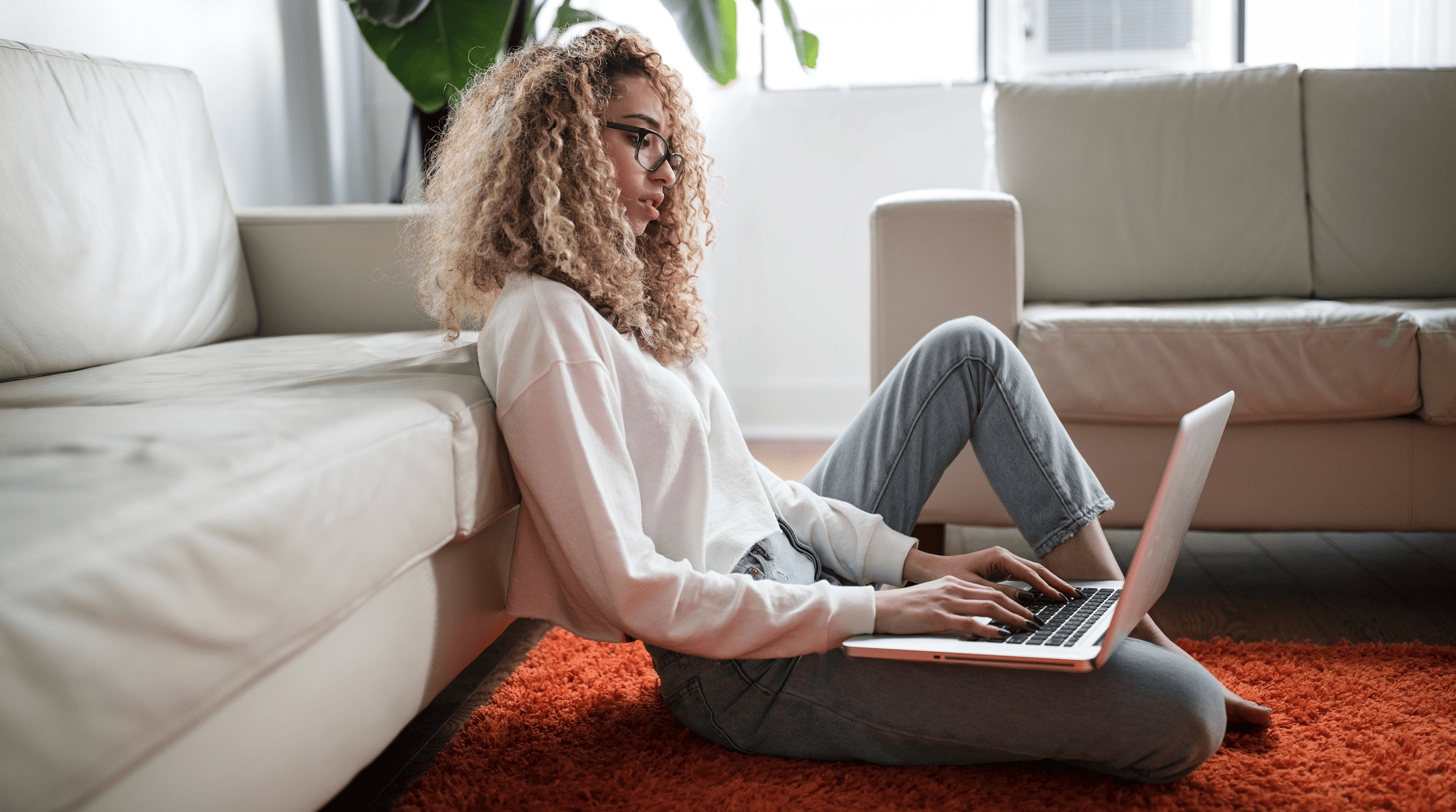 woman sitting in her living room and working on a laptop