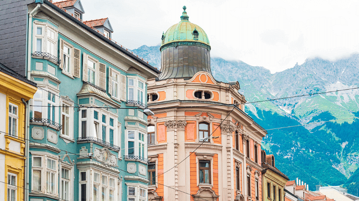 An image of colourful houses in Innsbruck Austrai against a backdrop of snowy mountains to illustrate a blog post entitled The Best Family Winter Holidays from Ireland