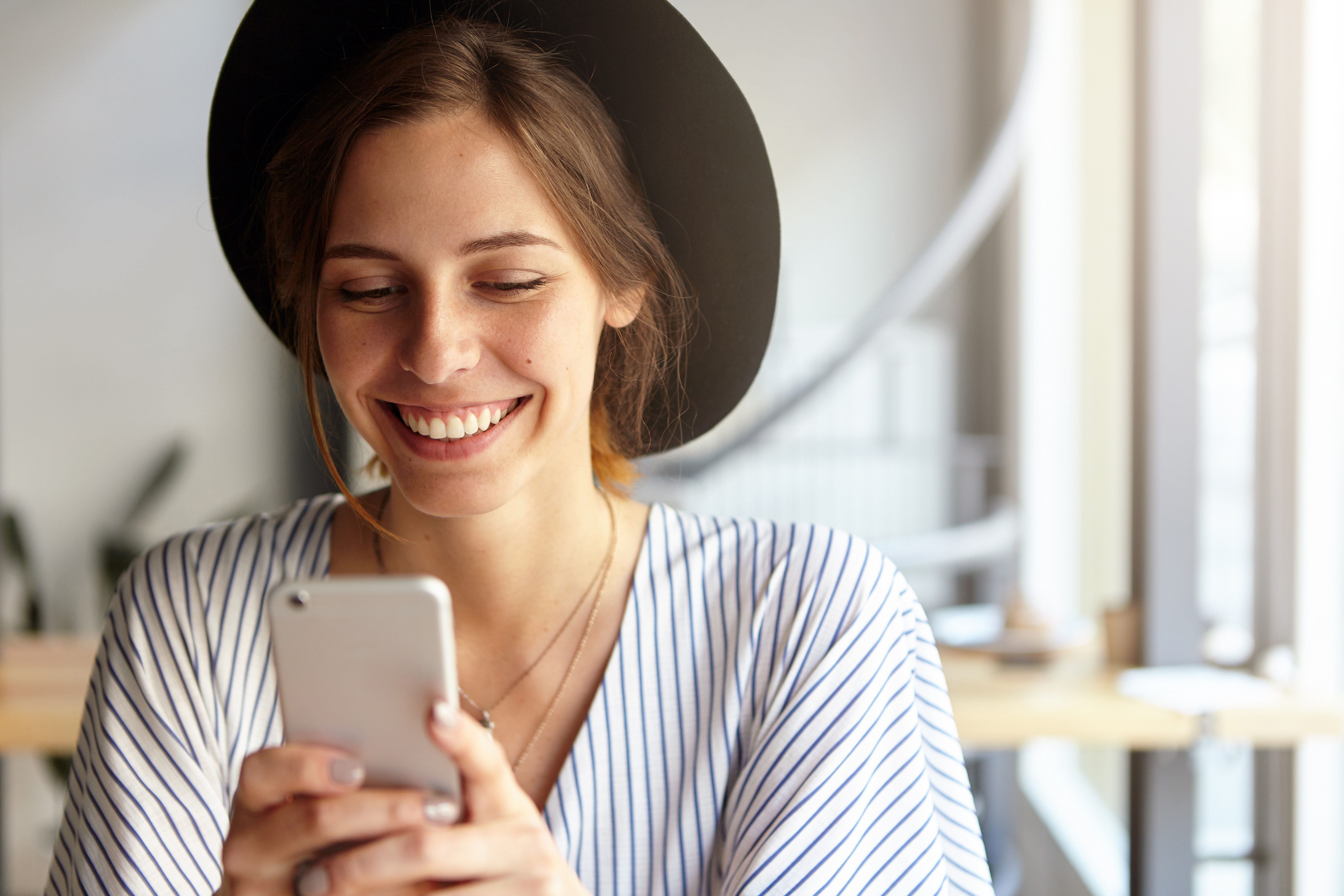 Young woman smiling and looking at a smartphone