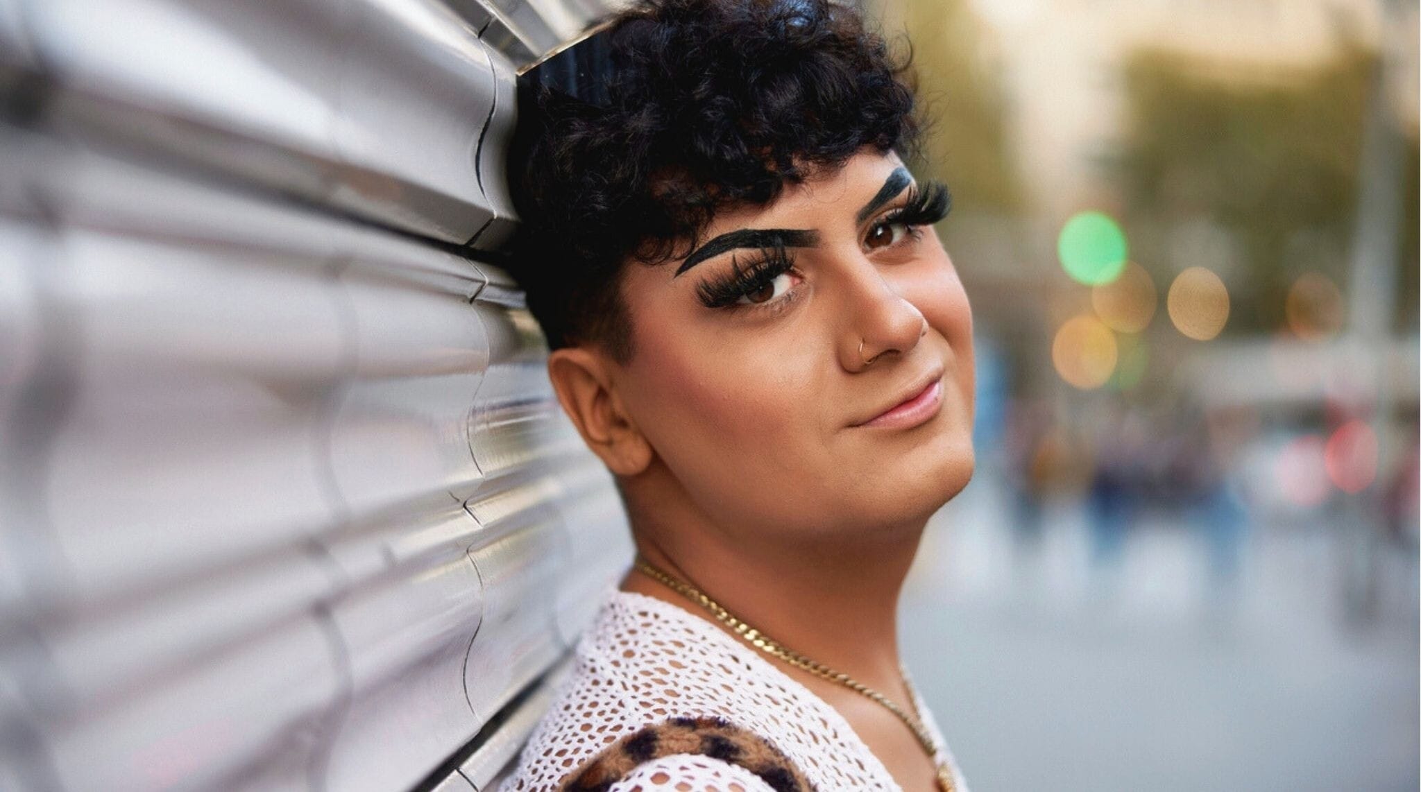 Joven queer posando en una calle de Barcelona al atardecer