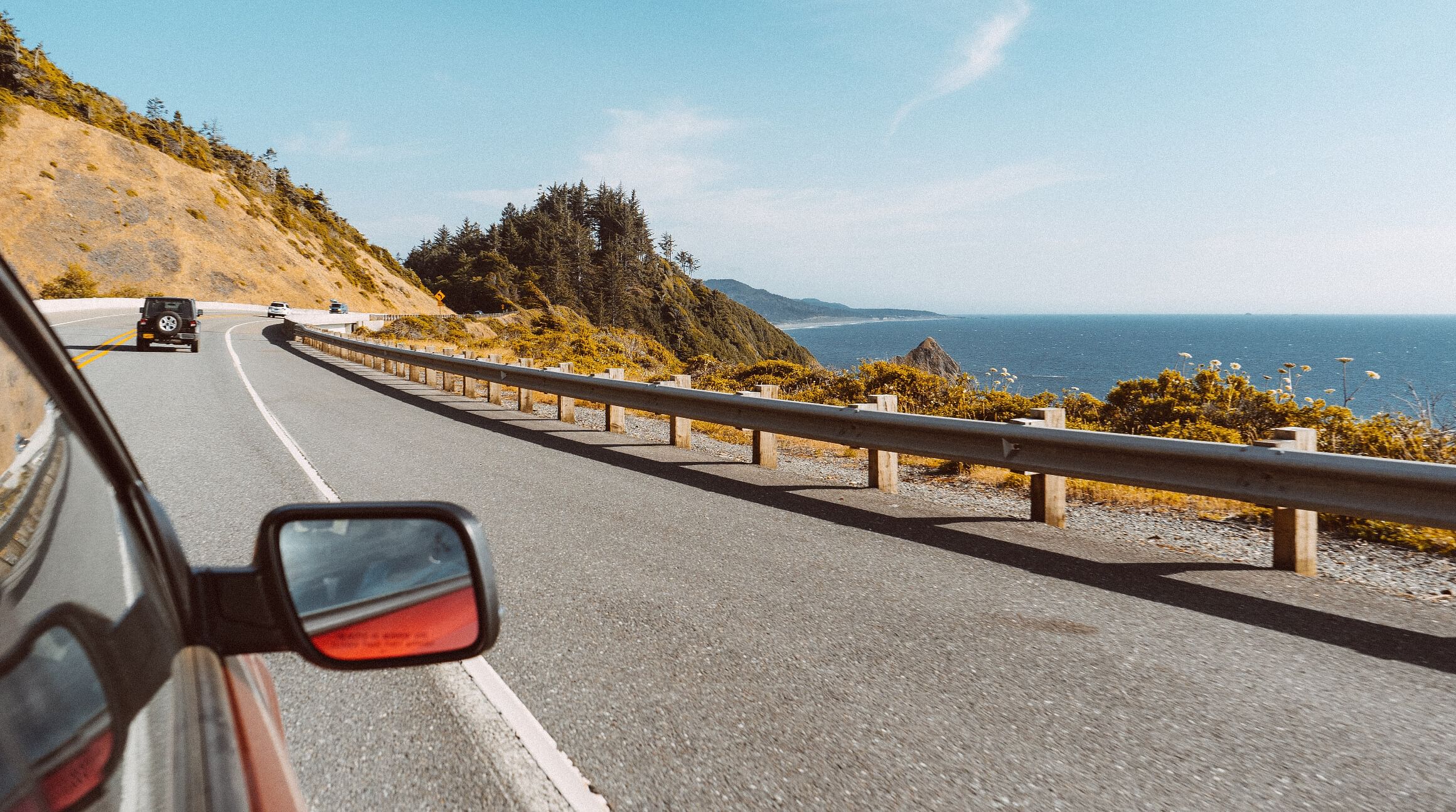 Passenger seat view of a car driving along the coast