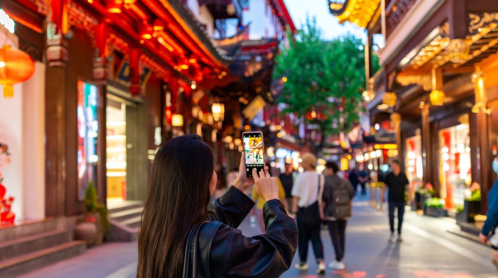 touriste avec son téléphone en main dans une rue en Chine