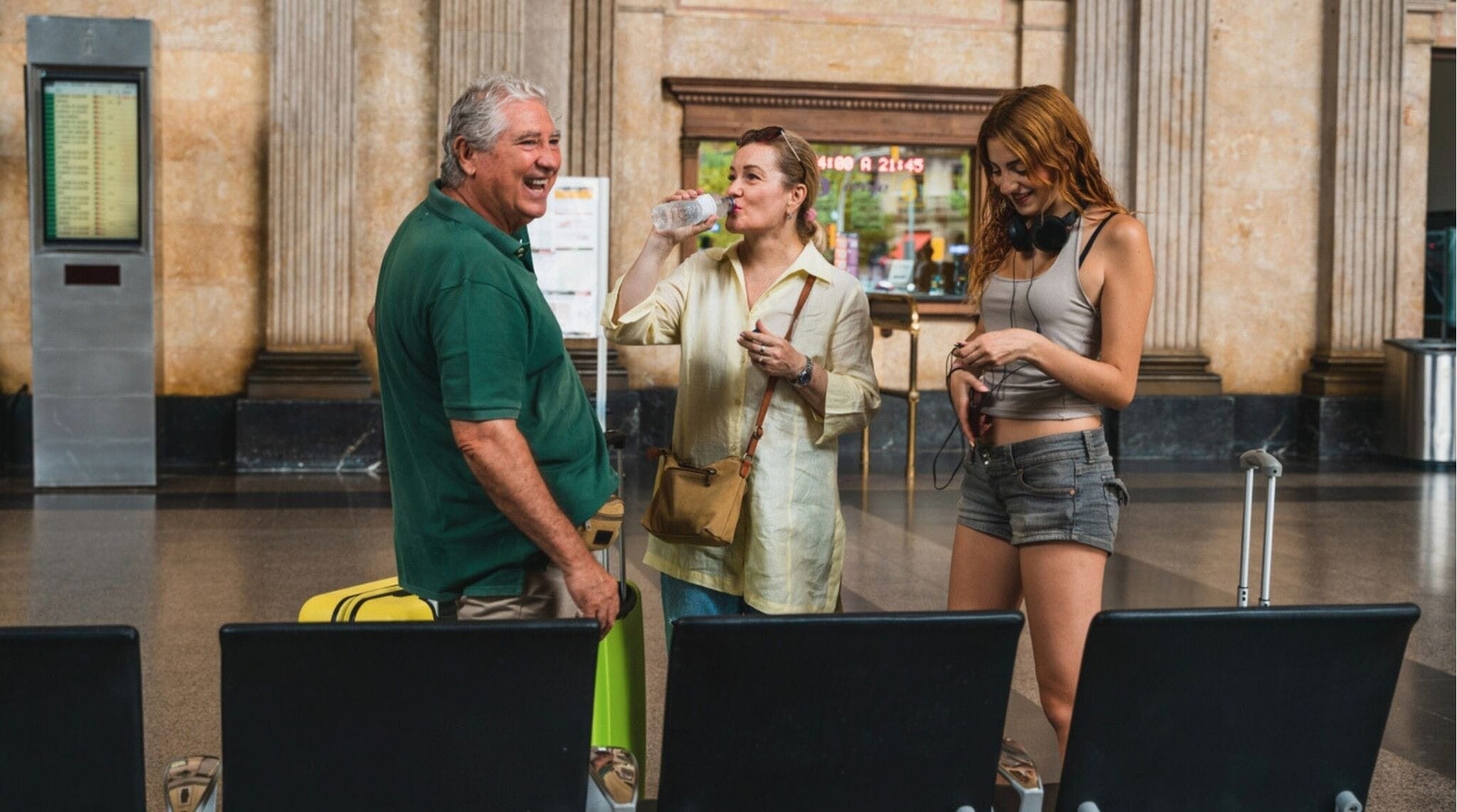 Familia latina esperando el tren en una estación europea con maletas de viaje