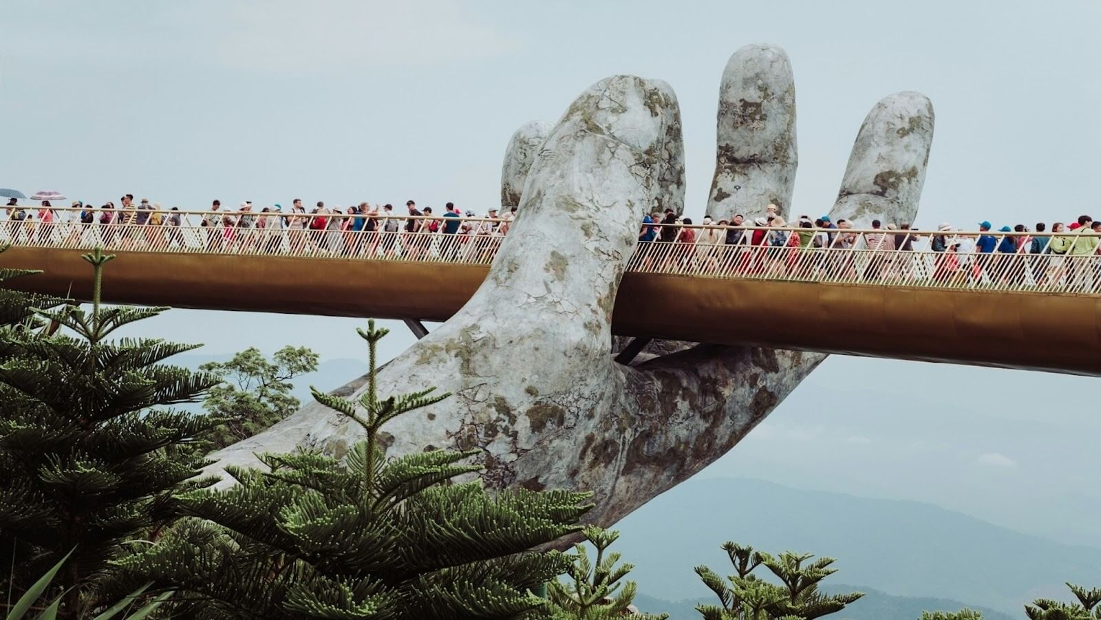 People walking on the Golden Bridge on Ba Na Hills, Vietnam, Da Nang during the day