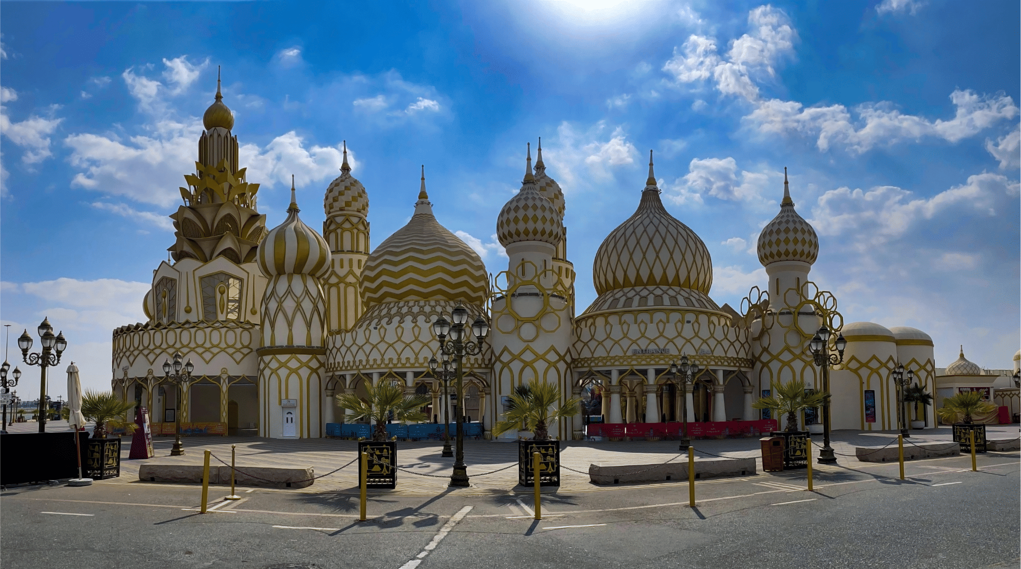  واجهة أحد الأجنحة الشهيرة في القرية العالمية دبي بتصميم القباب الذهبية والزخارف المميزة تحت سماء صافية