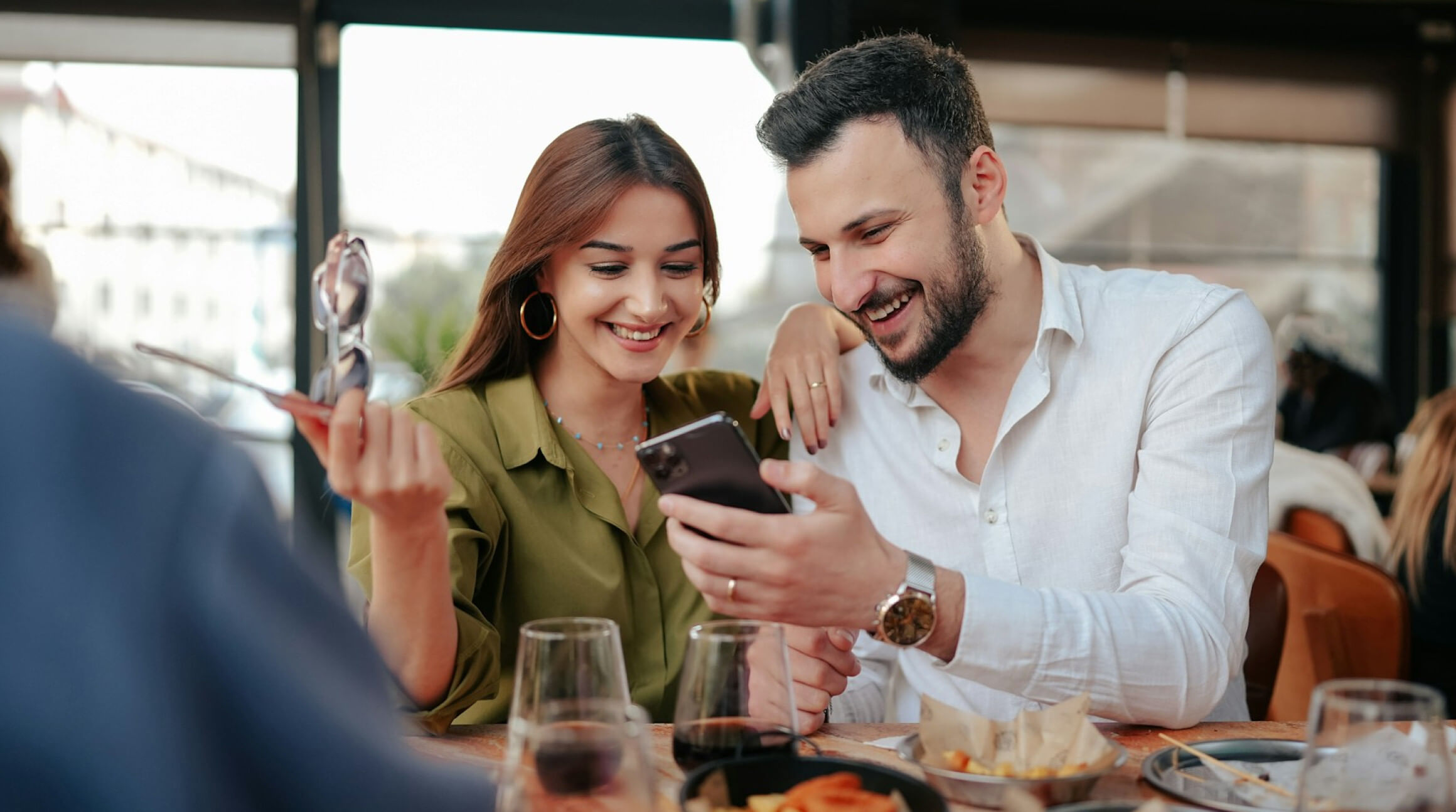 un couple telephone a la main, utilisant un iphone 15 double sim (dual sim)