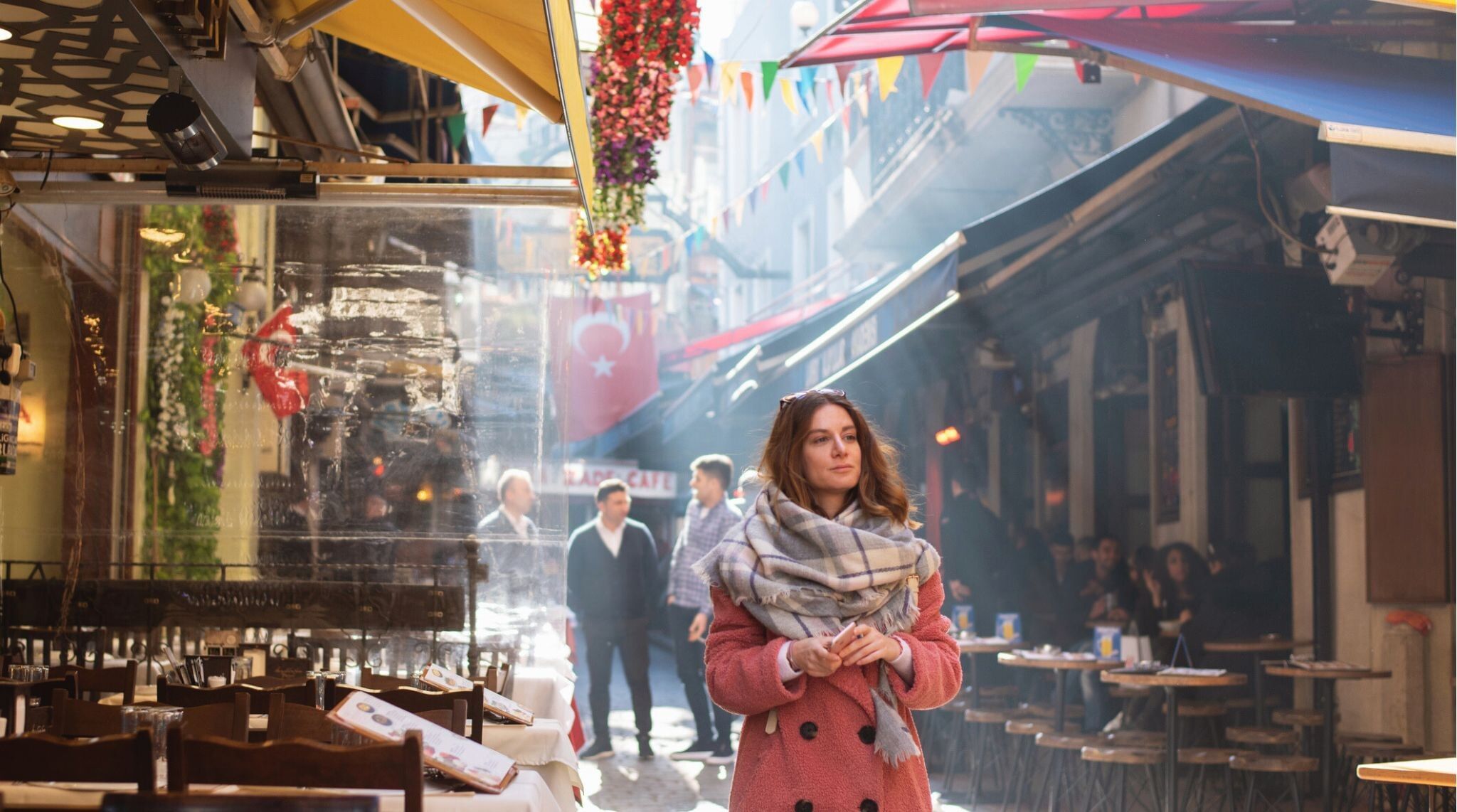 Mulher viajante caminhando por rua de restaurantes tradicionais em Istambul, Turquia.