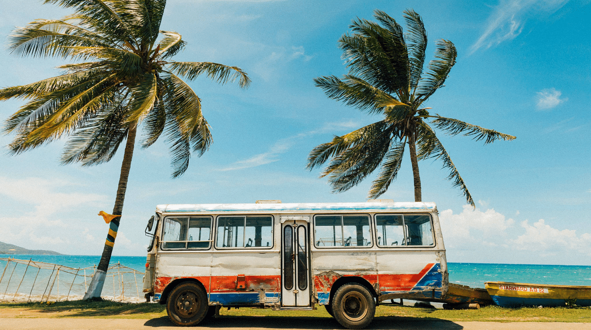 bus in front of palm trees and a beach in Jamaica