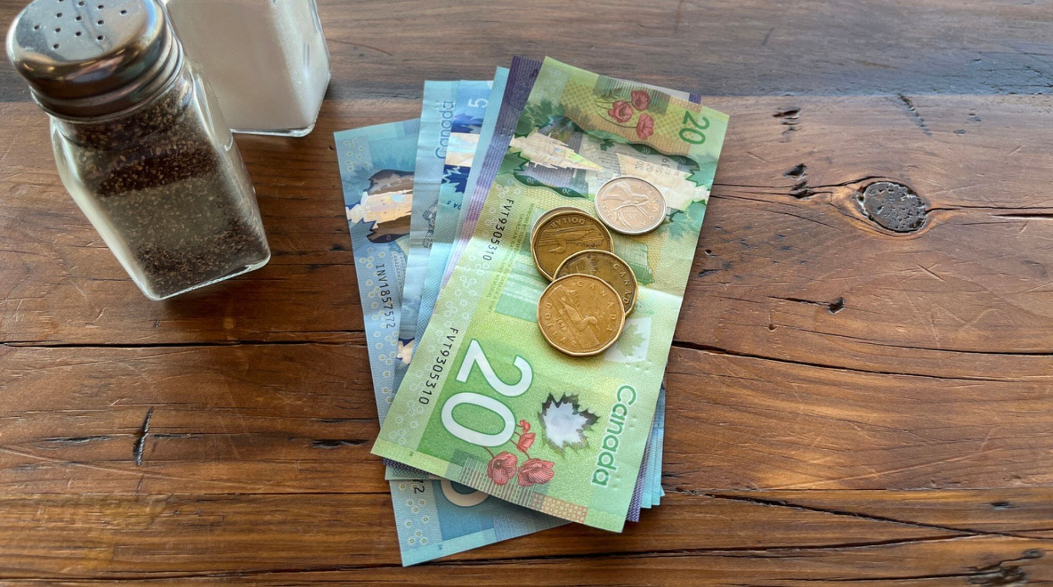 pieces et billets en dollars canadiens sur une table au restaurant