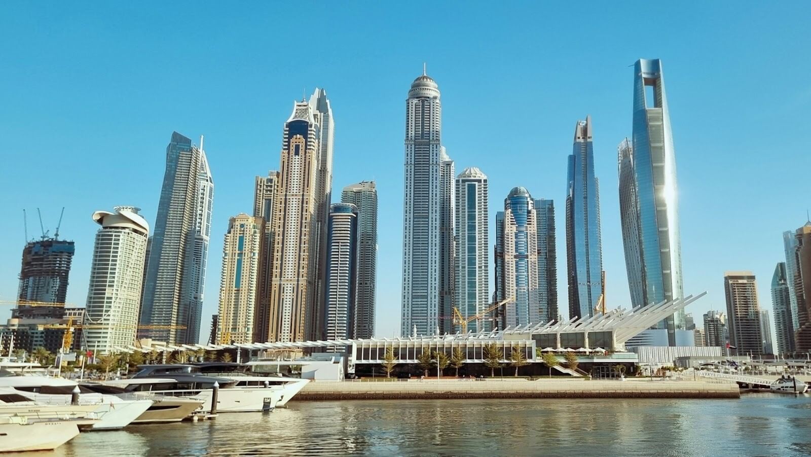 Boats on a large body of water surrounded by high-rise buildings in Dubai