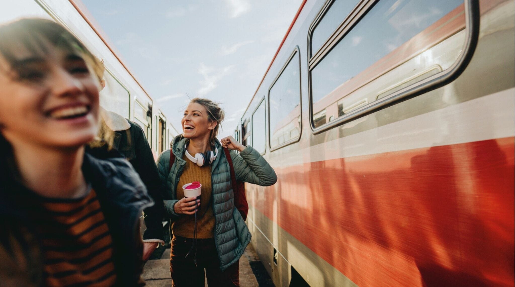 Foto de jovens mulheres esperando juntas pelo trem em uma estação ferroviária.
