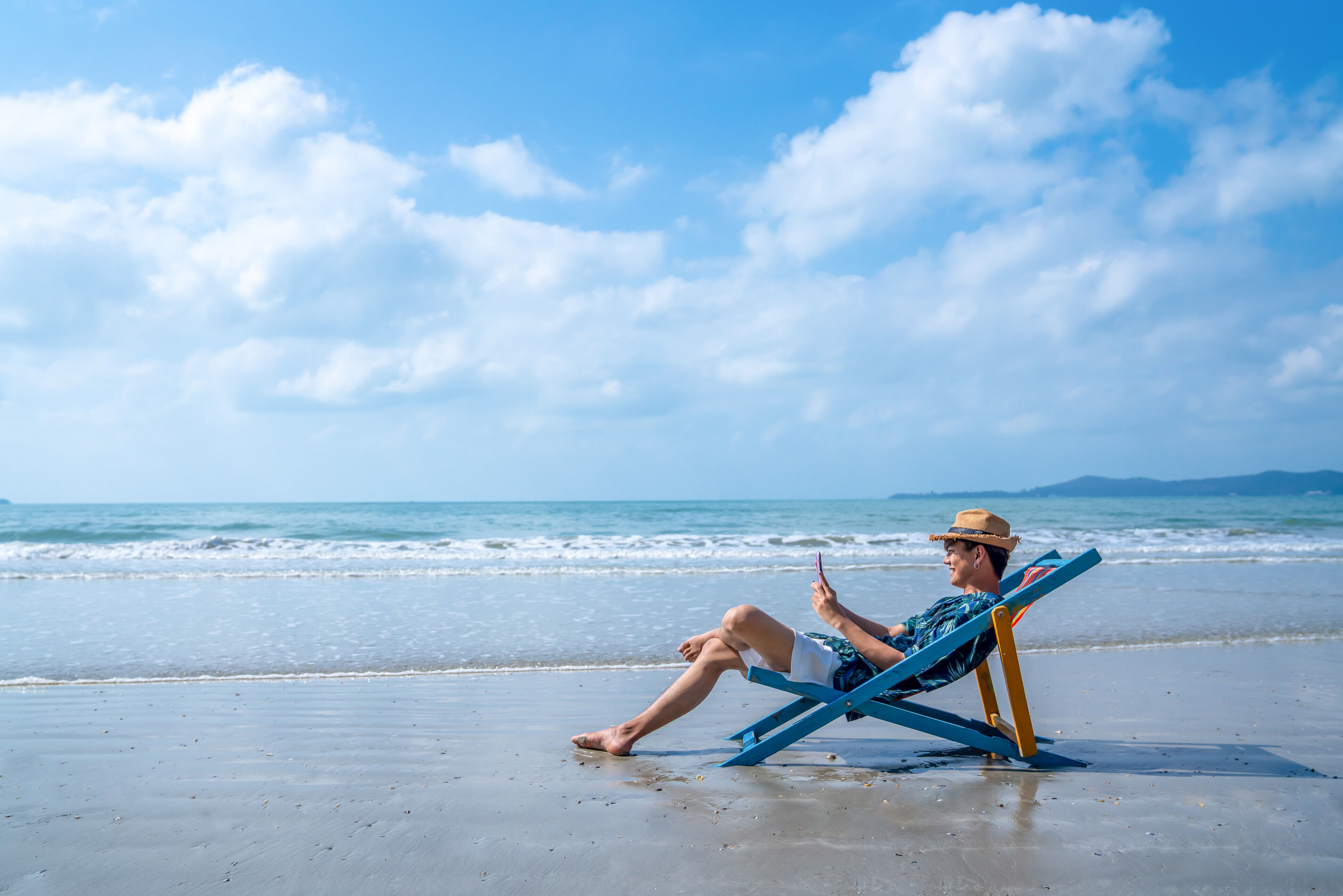 Mann mit eSIM am Strand