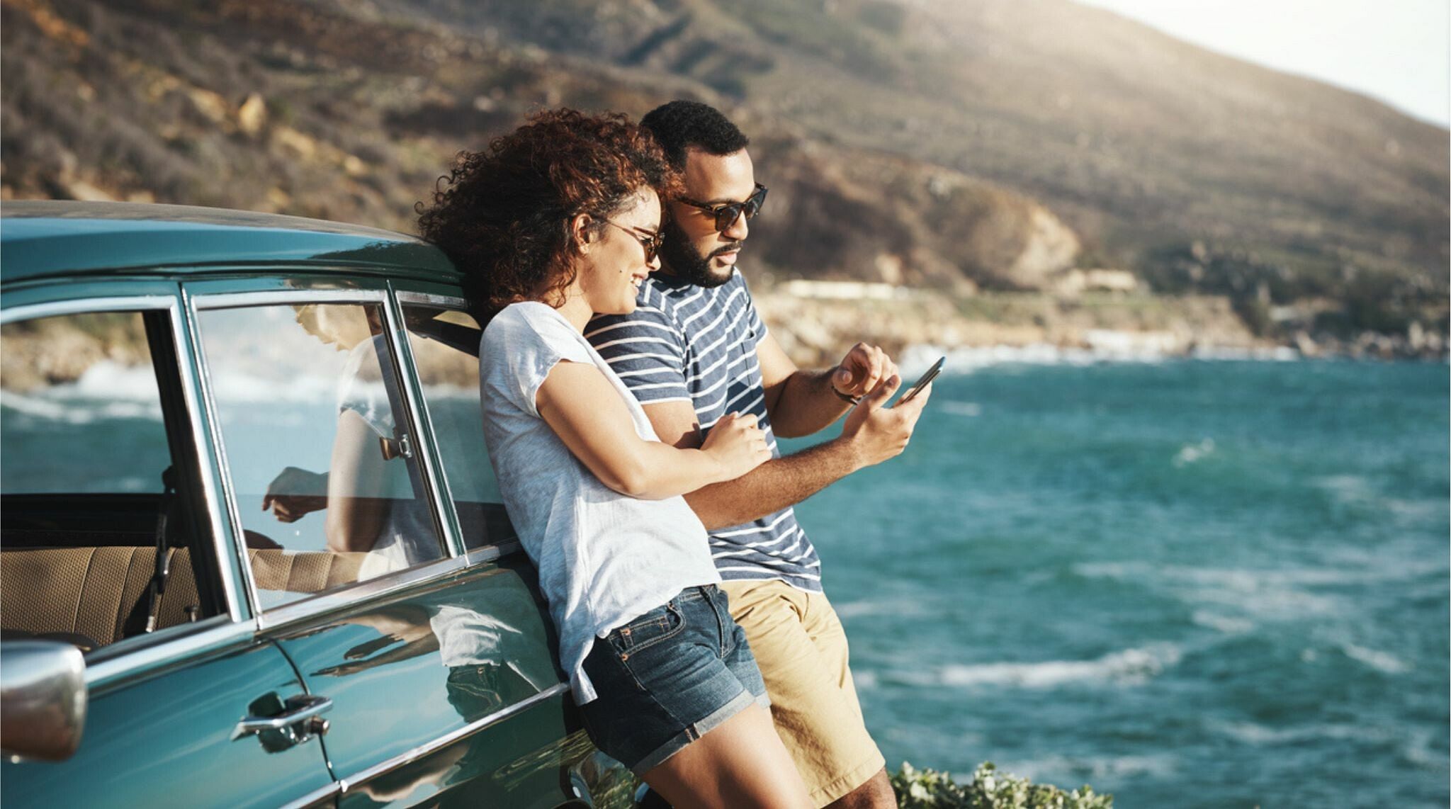 casal utilizando celular na estrada durante viagem