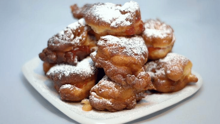 An image of the Bulgarian fried donut mekitsa, topped with powdered sugar and filled with jam, for a blog post mentioning capital city Sofia, entitled Extreme Day Trips Abroad from the UK.