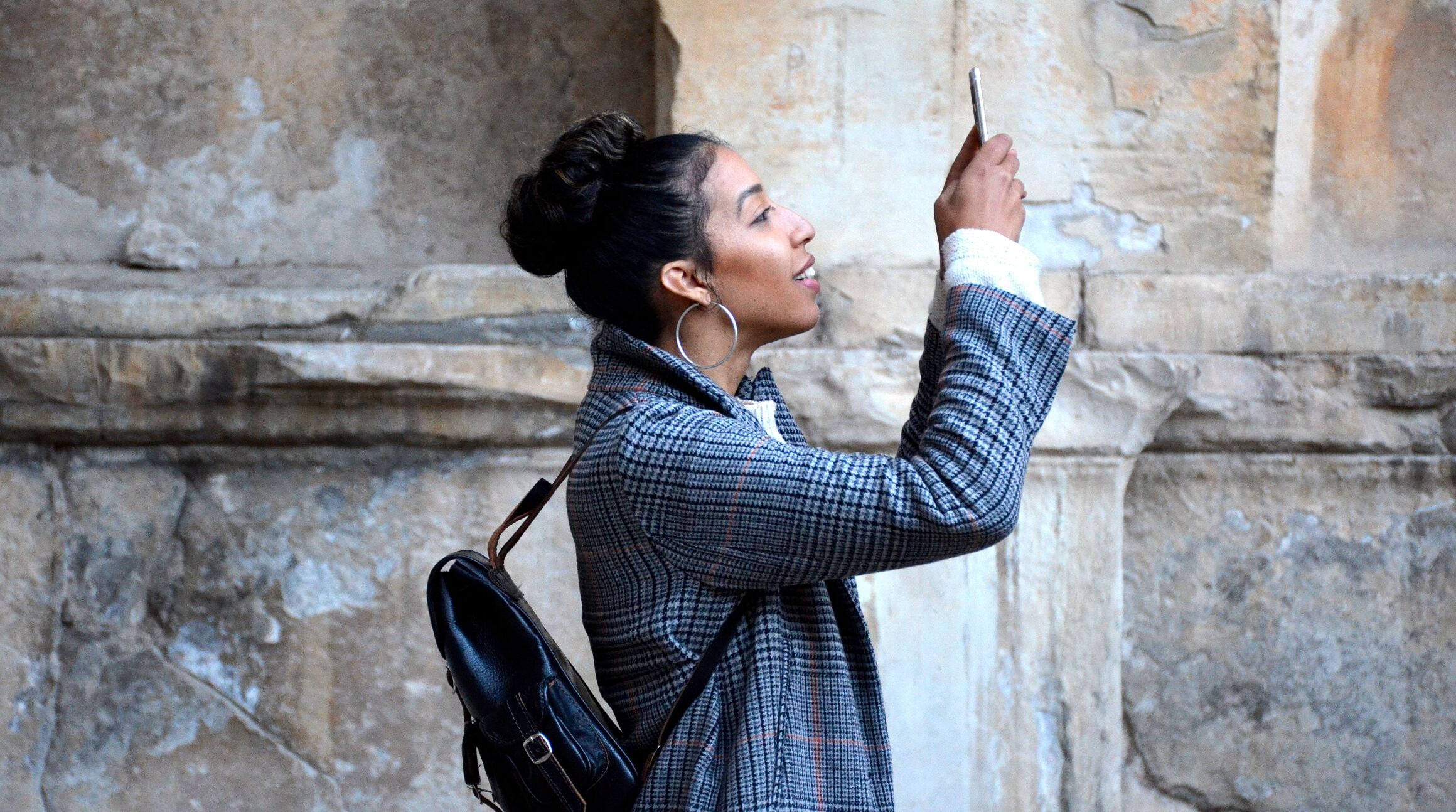 mujer sosteniendo su smartphone y buscando señal