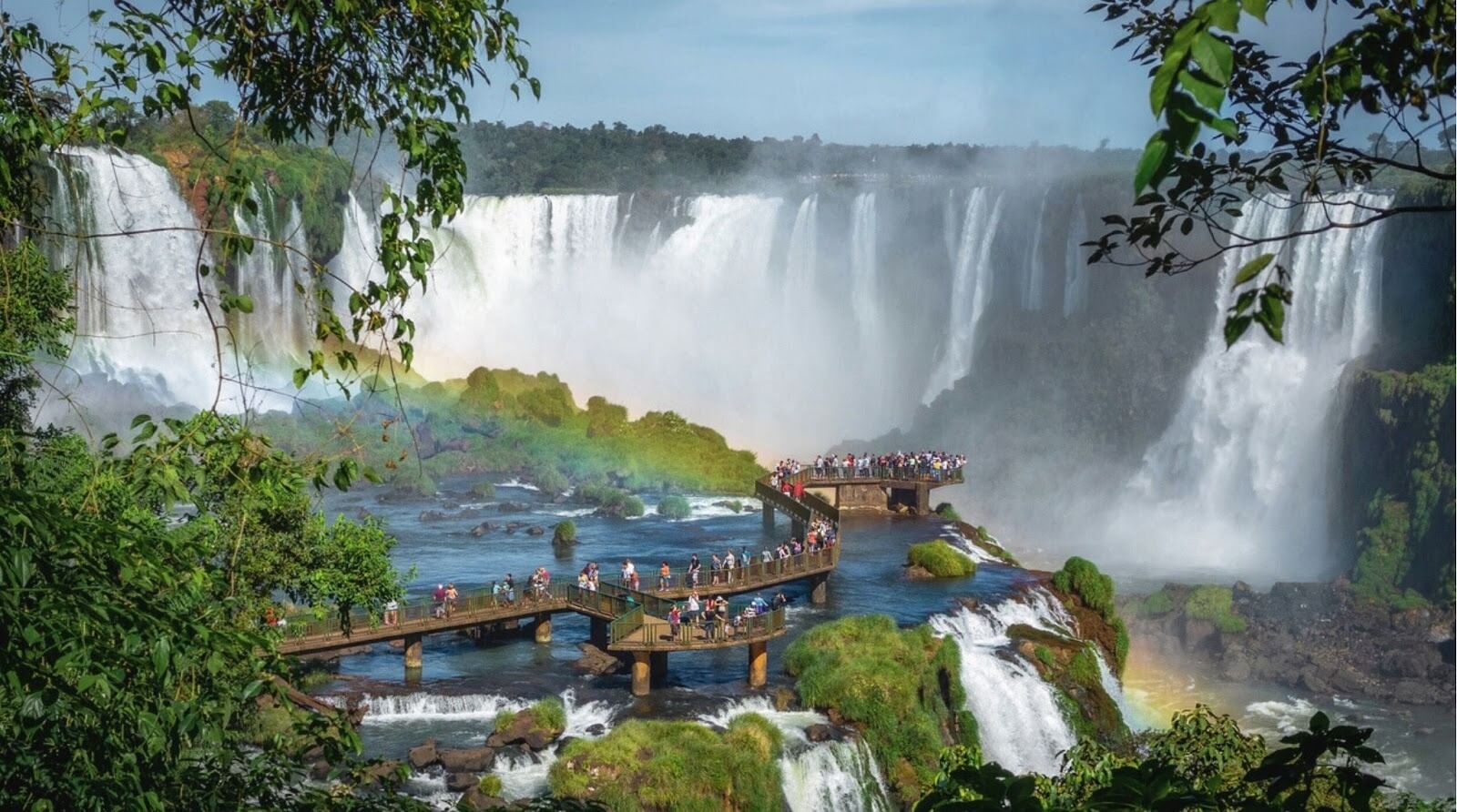 Lugares mais lindos do mundo: Turistas explorando as Cataratas do Iguaçu, na fronteira entre o Brasil e a Argentina.