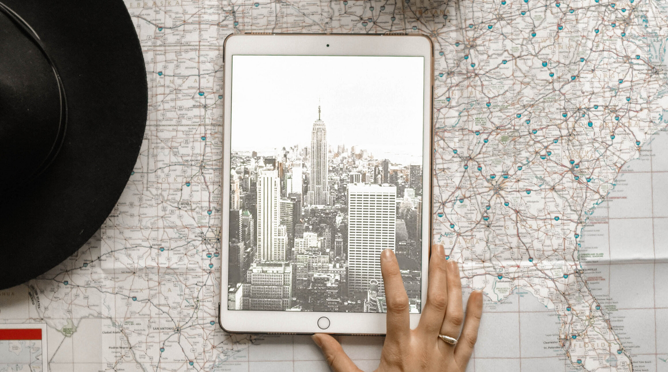 ipad with a picture of the eiffel tower on it sitting on top of a world map