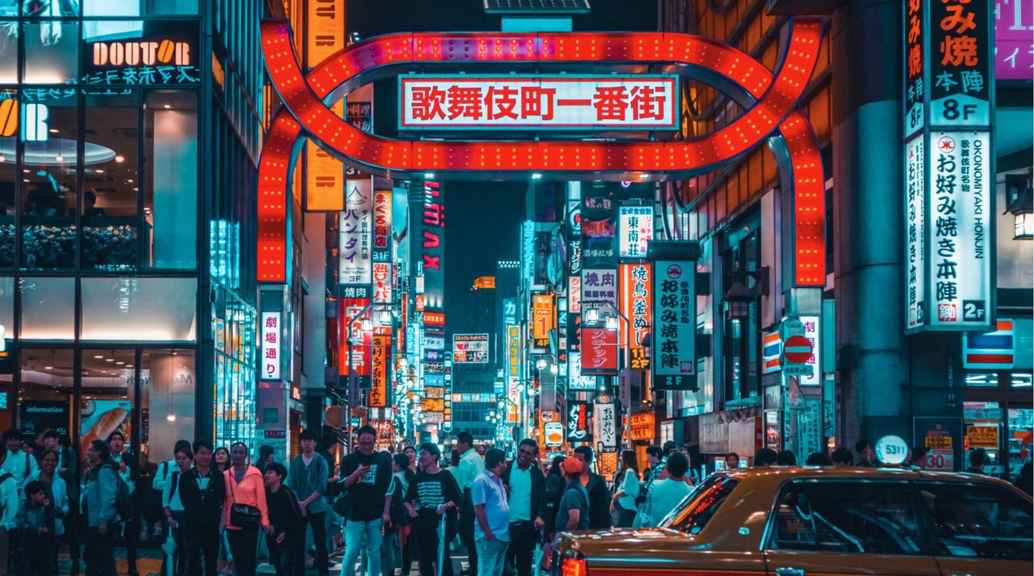 Calle de Kabukicho en Shinjuku iluminada con carteles luminosos y vida nocturna.