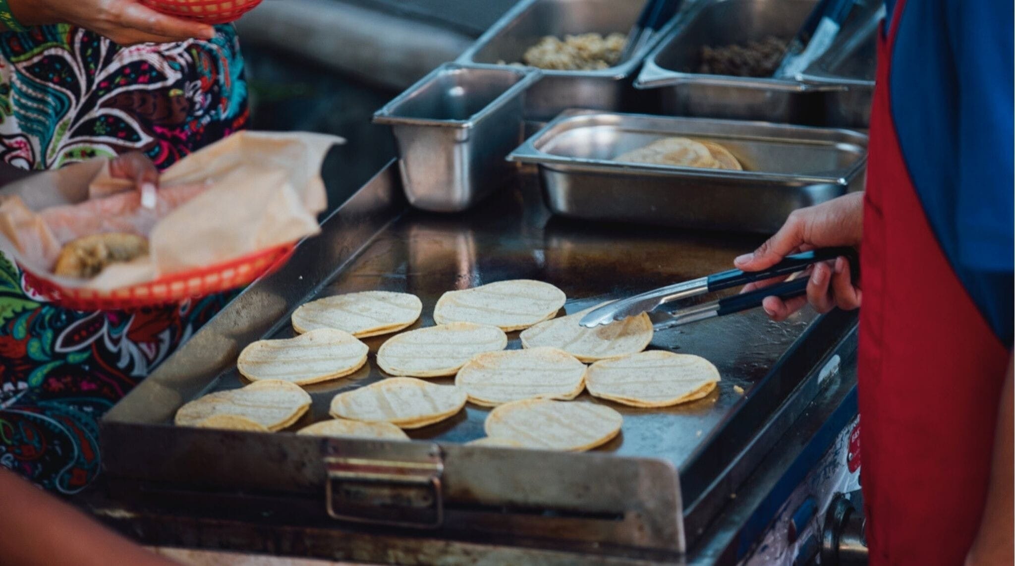 Cocinero preparando tacos en un carrito de comida callejera en Estados Unidos.