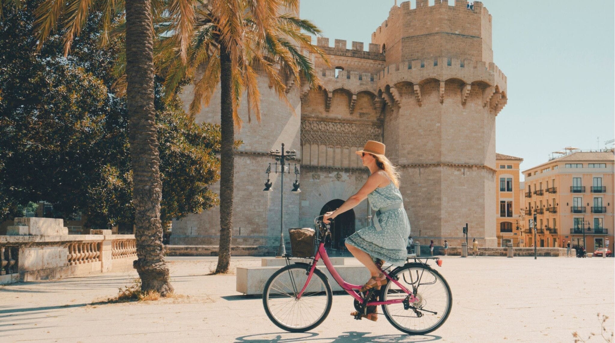 Mulher andando de bicicleta pelo Portão Torres de Serranos, em Valência, Espanha.