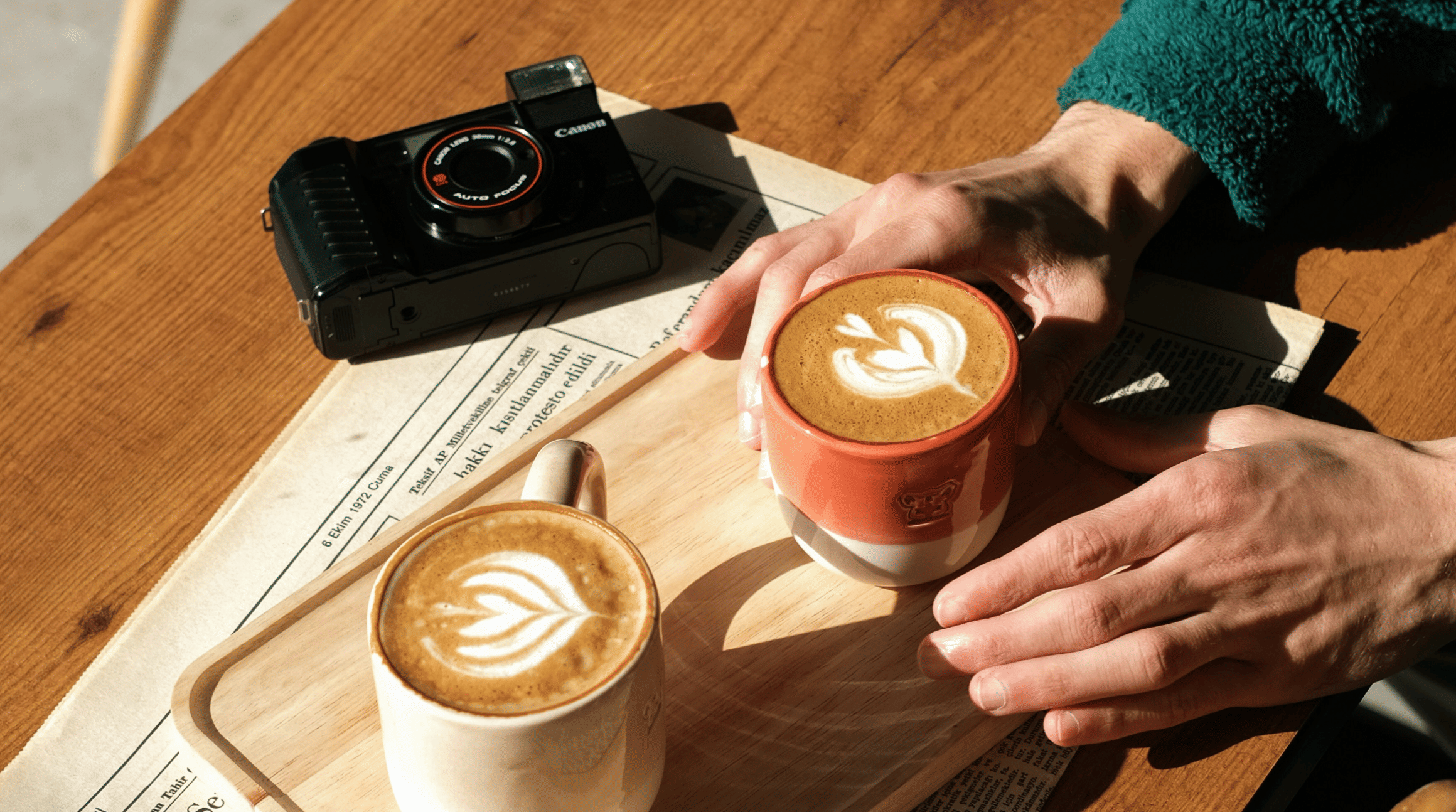 An image of two hands moving an artesenal coffee in a ceramic glass towards them. The coffee is toped with impressive latte art and looks delicious and modern. To illustrate a blog post entitled 'Which Country Has the Best Coffee Culture?'