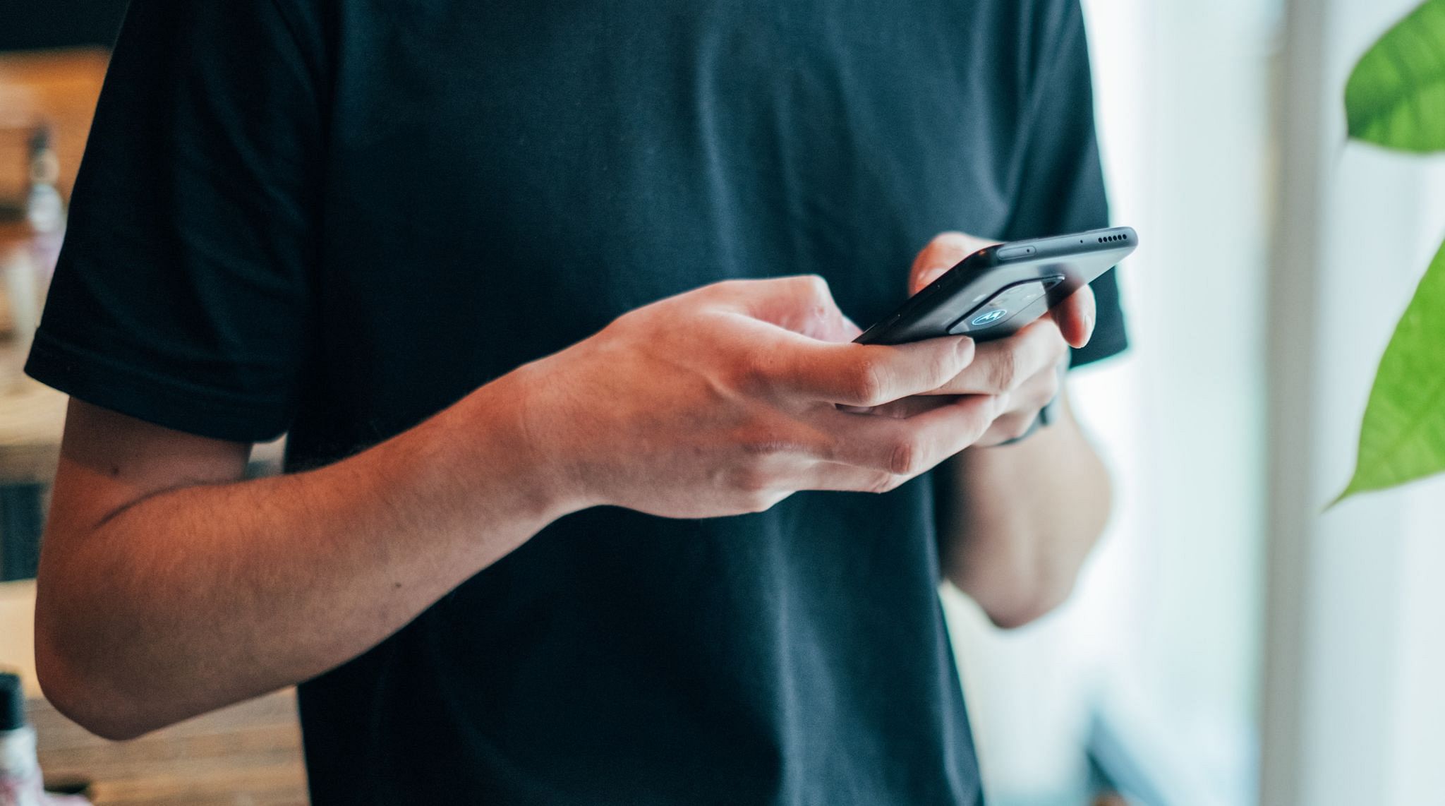 hombre sosteniendo un teléfono móvil