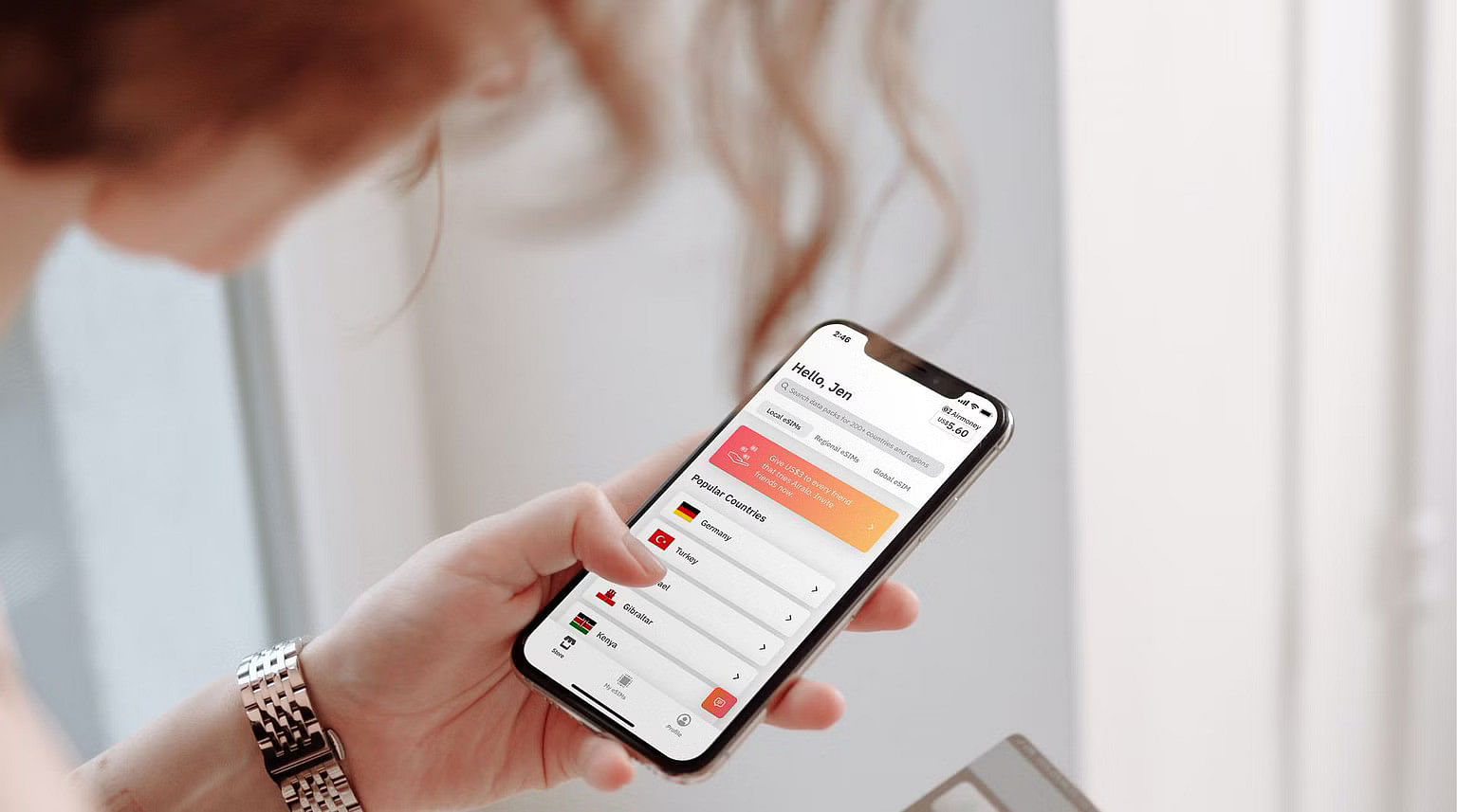 akıllı telefonunda Airalo eSIM uygulamasına göz atan kadın