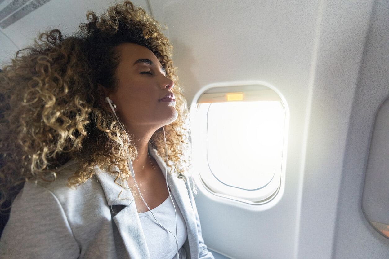 Woman listening to music in plane