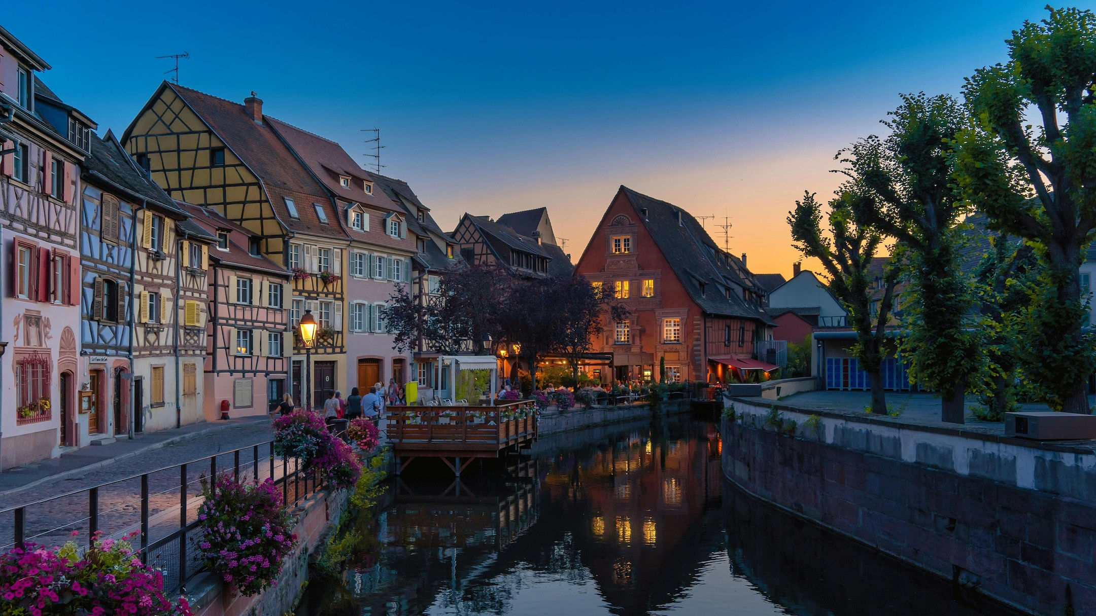 Colorful half-timbered houses along a flower-lined street in Alsace, France