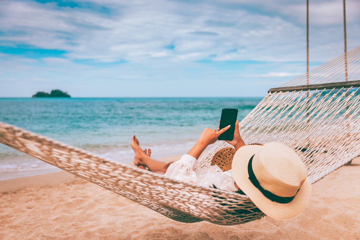 Frau mit eSIM im Ausland am Strand