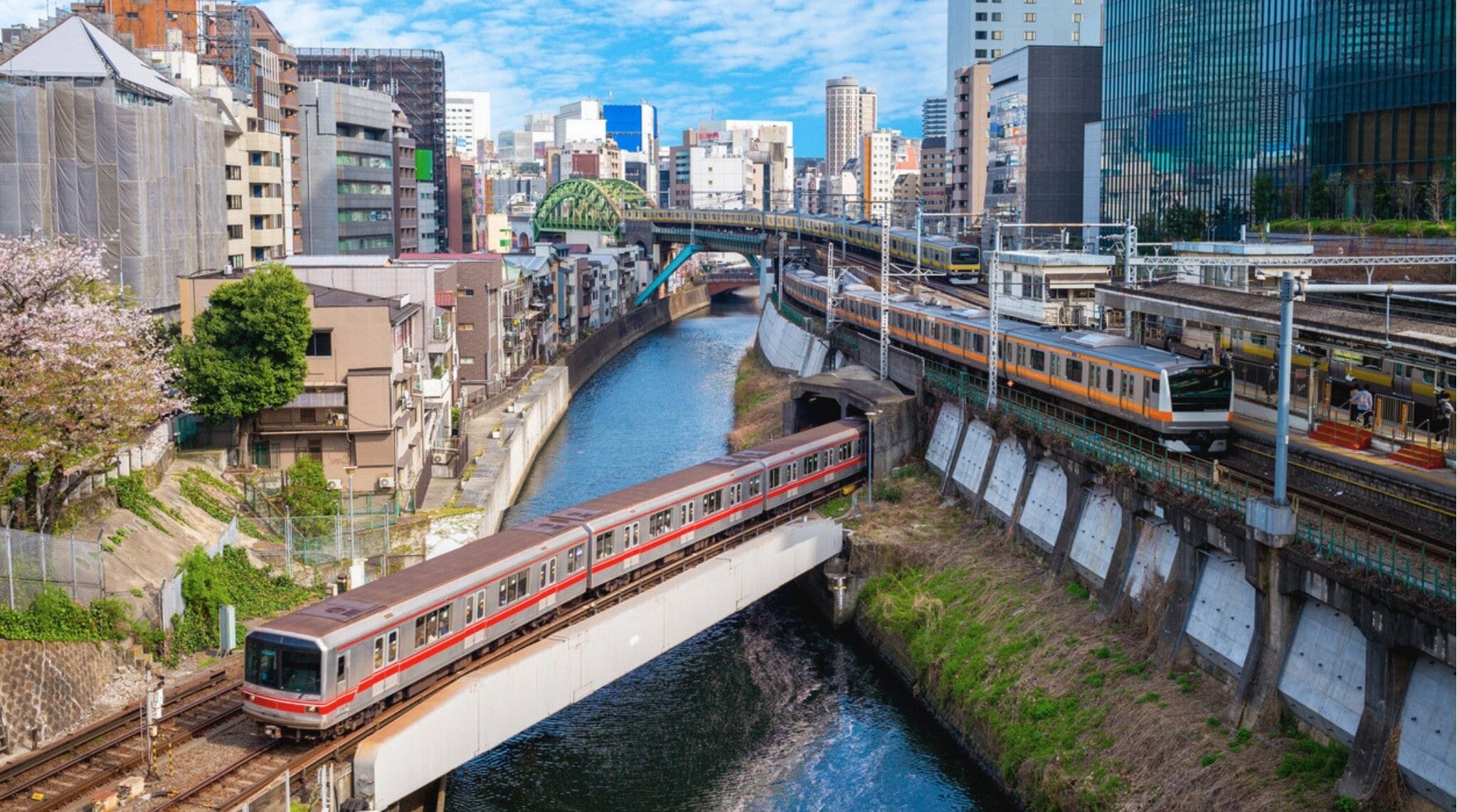Interior del metro de Tokio con pasajeros sentados y agarrados a las barras.