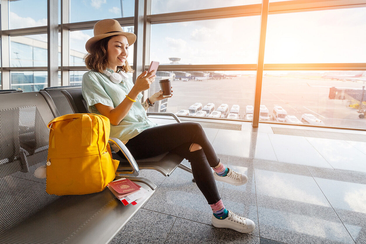 Frau mit Handy am Flughafen